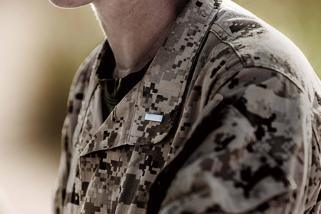 Marine in cammies with a pin on lapel.