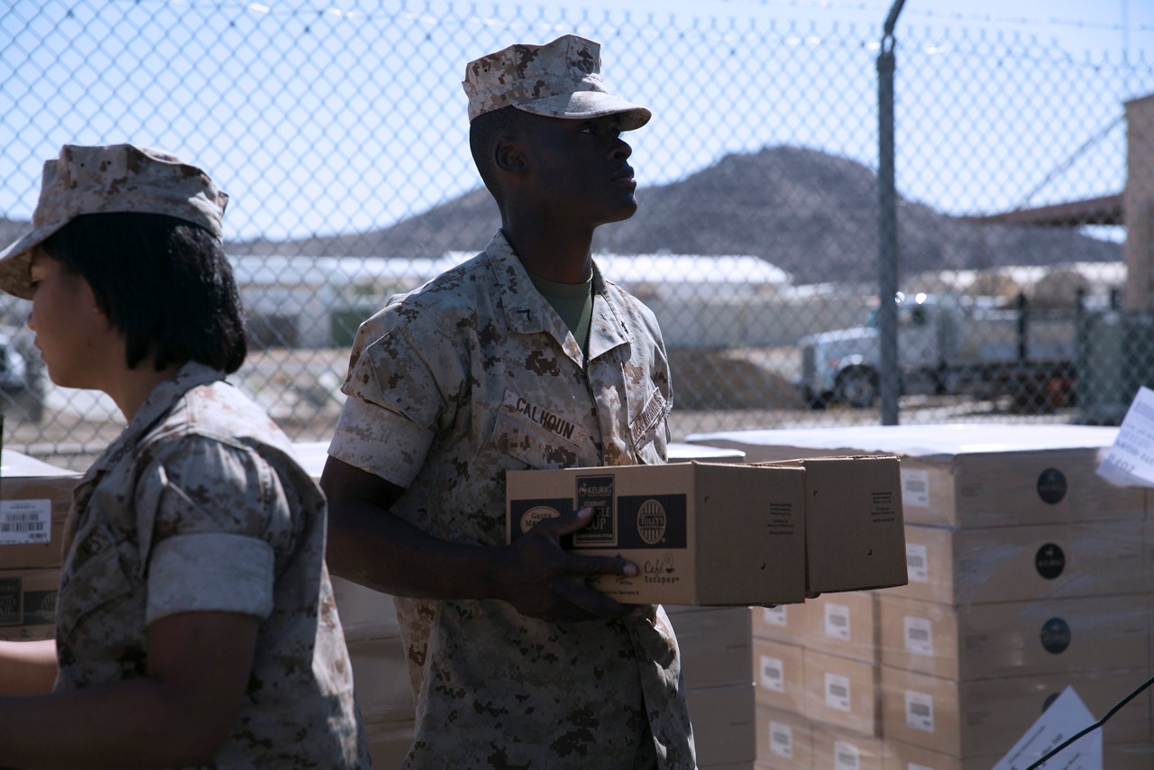 Marine moving boxes of coffee during the Chaplain’s coffee giveaway at the Distribution Management Office.