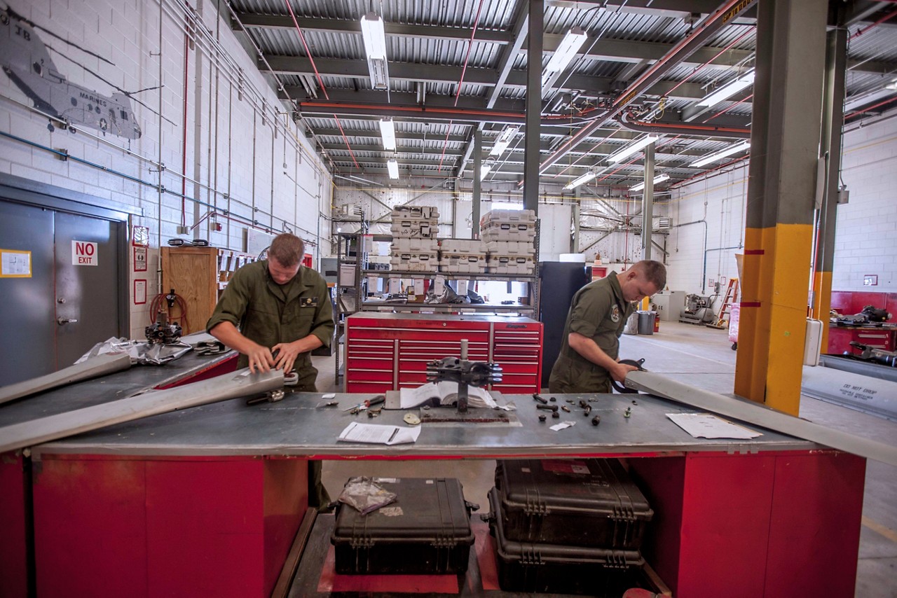 Marines assembling components as part of their aviation logistics MOS field duties.