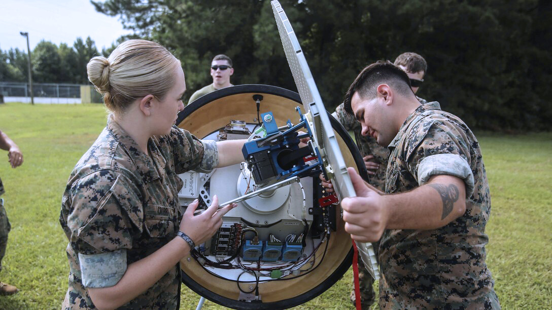 Marines in the meterology & oceanography MOS field setting up equipment.