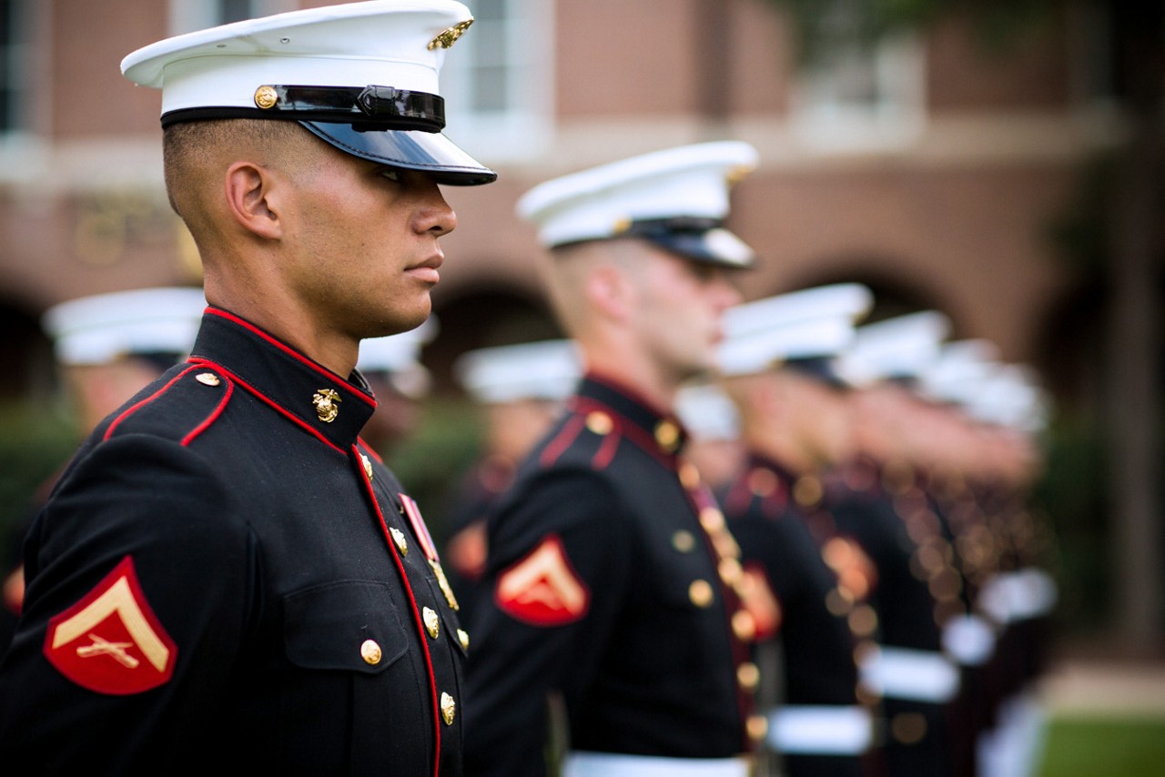 Marines standing at attention while wearing dress blues.
