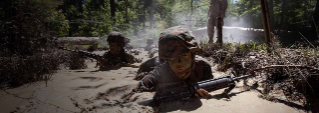 Aspiring Marines crawl through muddy water with barbed wire overhead at recruit training.
