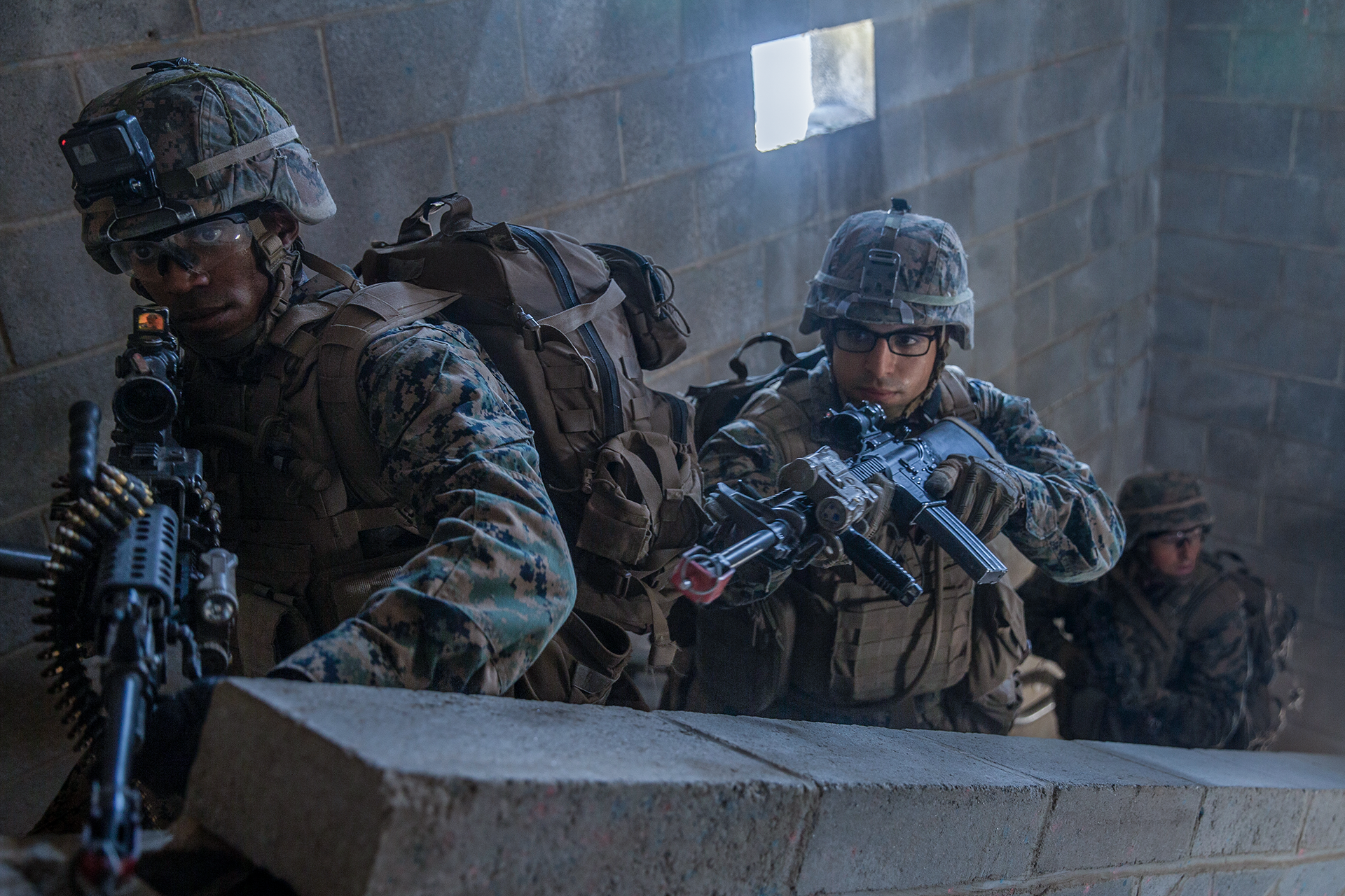 Marine officers in tactical helmets with rifles conducting Phase 4 MAGTF officer skills training during urban combat exercise.