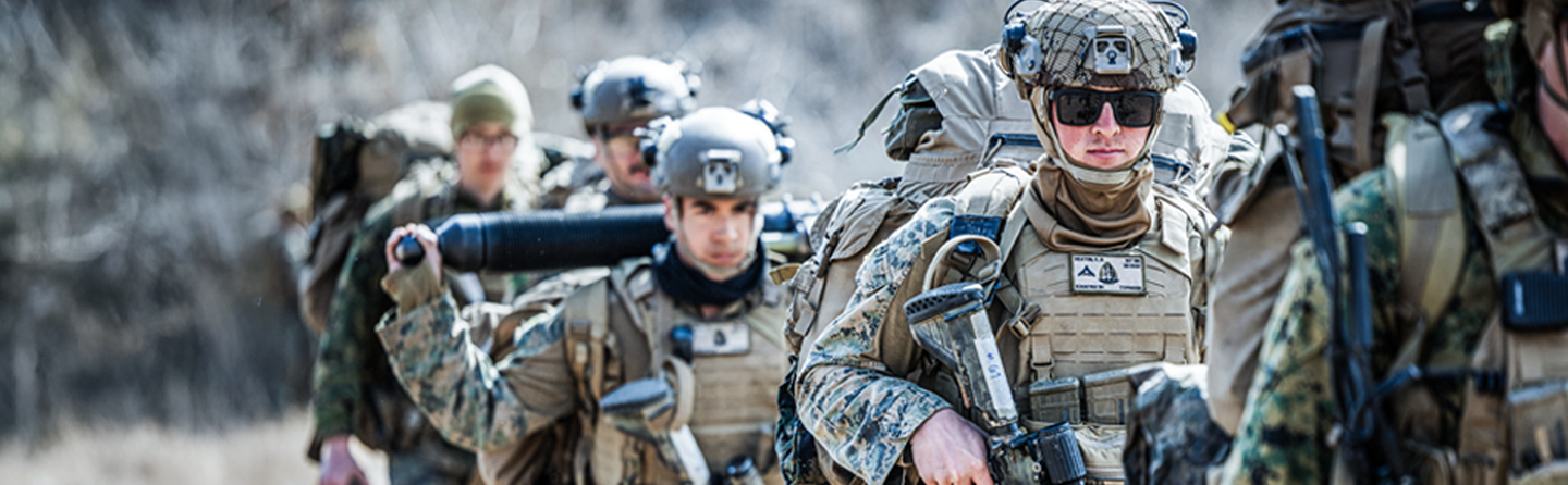 Marine Corps Reserve Marines in full combat gear and helmets during military training exercise.