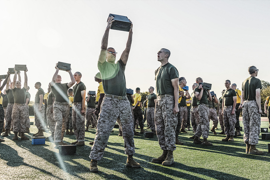 Marine recruits performing overhead ammo can lifts during Combat Fitness Test physical fitness assessment.