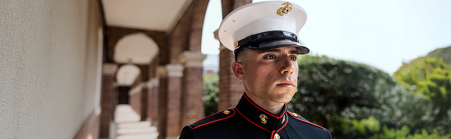 Marine in dress blue uniform exemplifying the high standards of Marine Corps enlistment requirements.