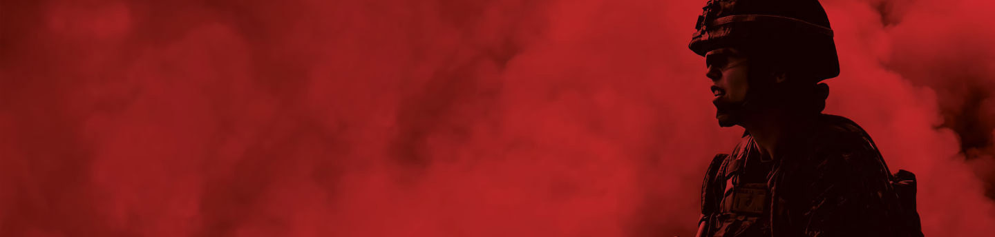 Silhouette of a Marine in profile, wearing a helmet, against a red, smoky background with a dark fade on the left.