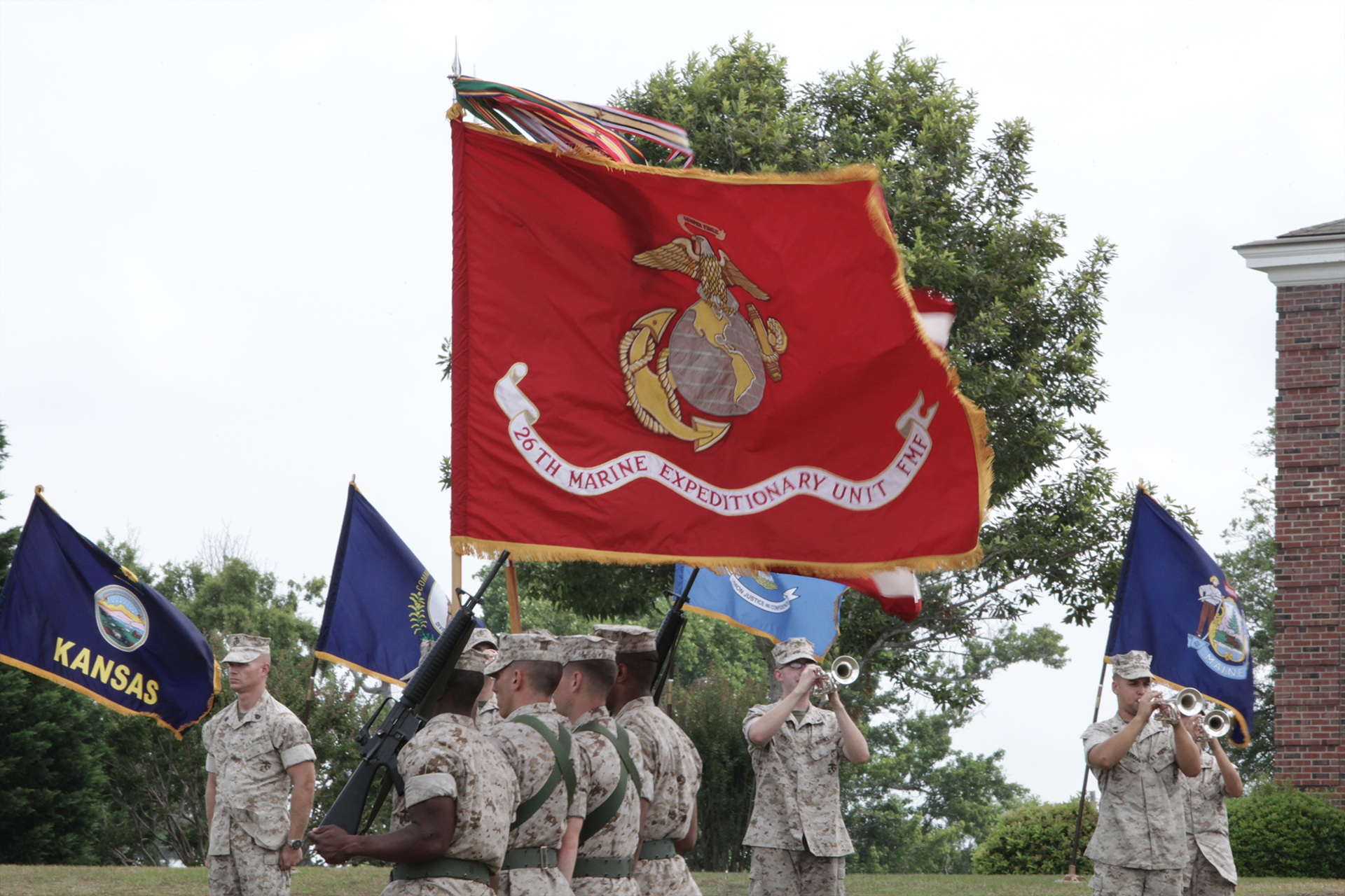 Marines in dress uniform holding 26th Marine Expeditionary Unit flag with state flags during ceremony.