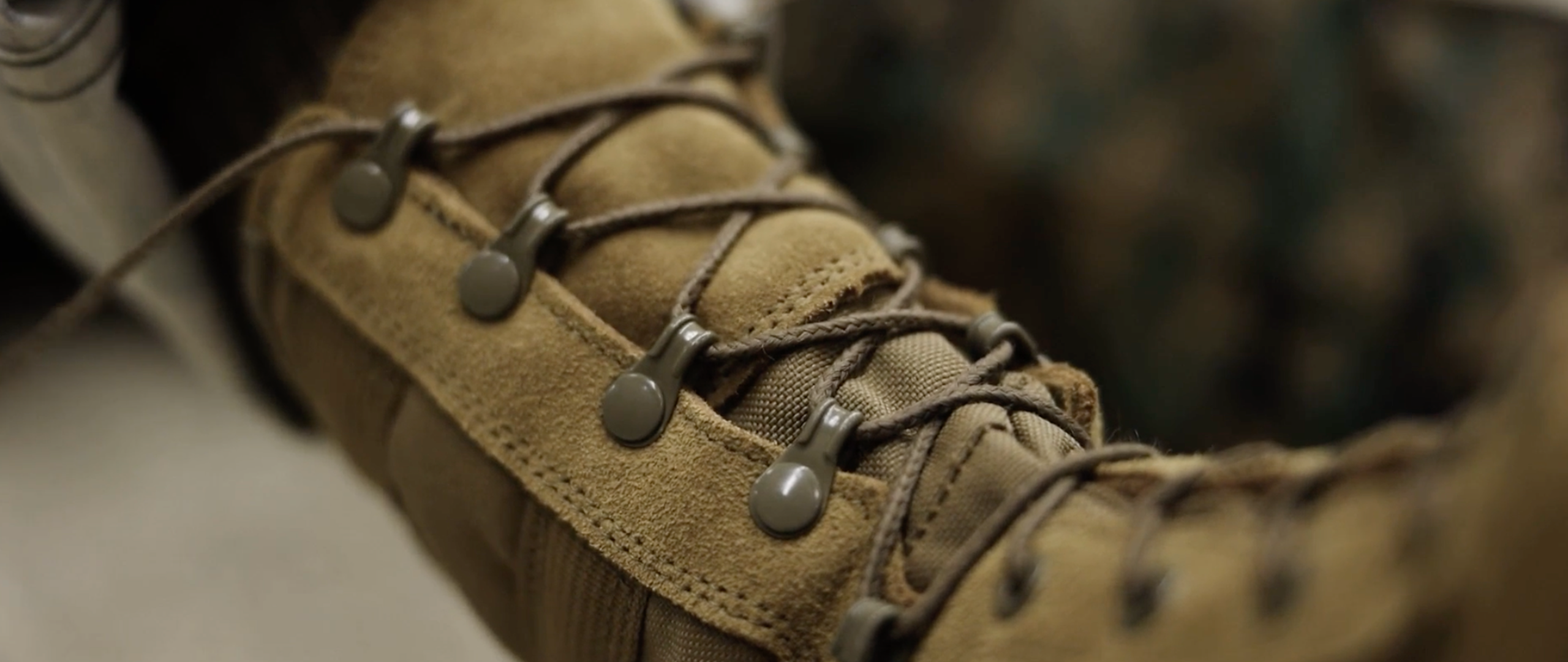 Marines in camouflage uniforms and boots, marching.