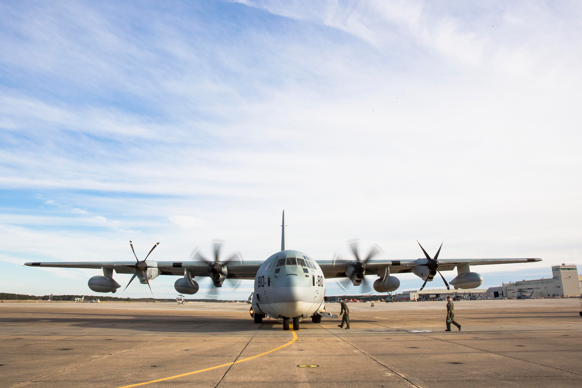 KC-130J Super Hercules cargo aircraft with four turboprop engines on flight line with ground crew performing checks.