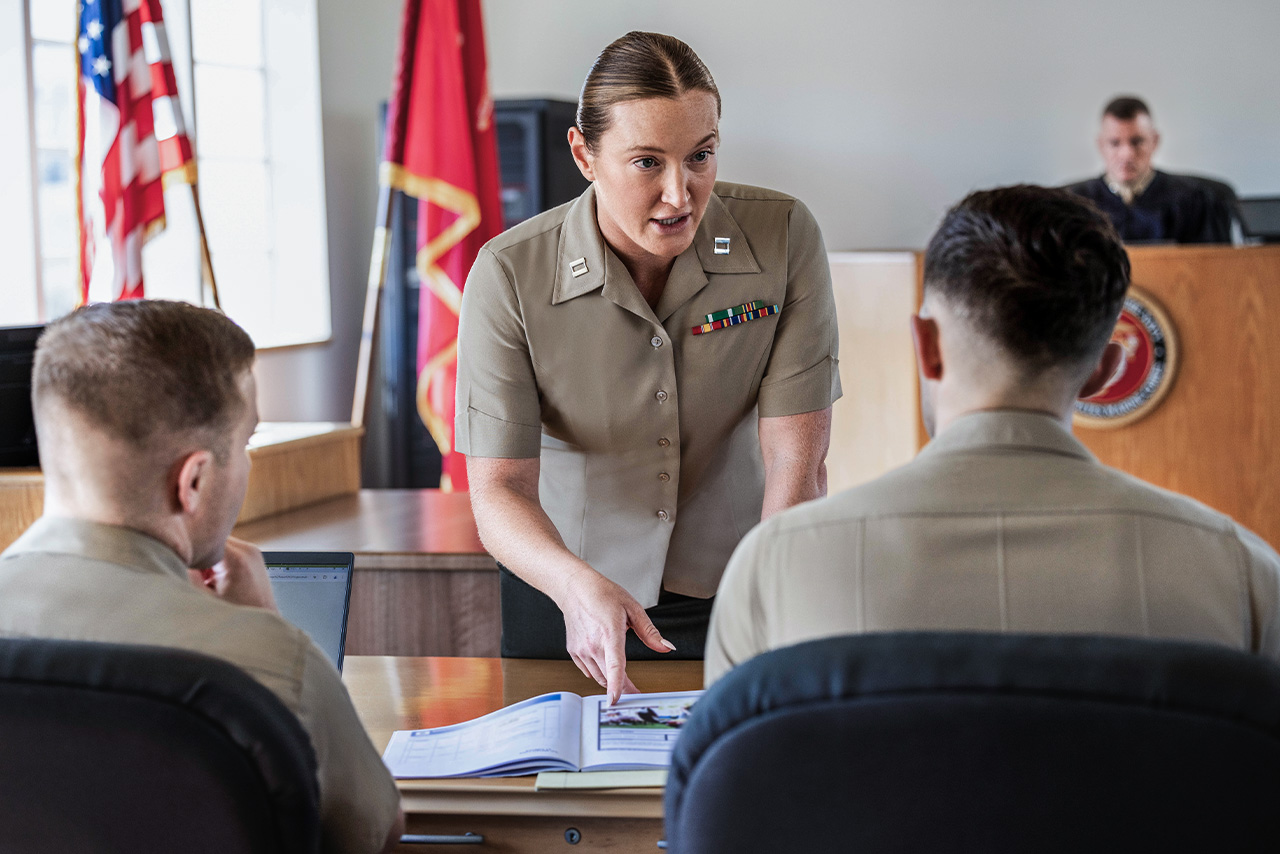 Marine judge advocate in dress uniform presenting case during military courtroom proceedings.