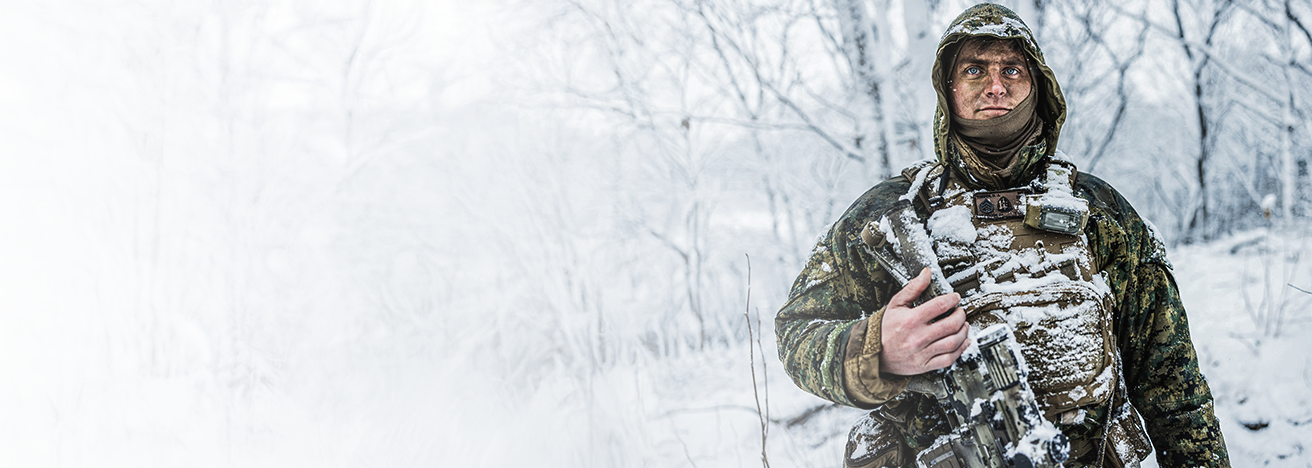 A Marine in cold weather gear with radio and tactical vest during winter training in South Korea.