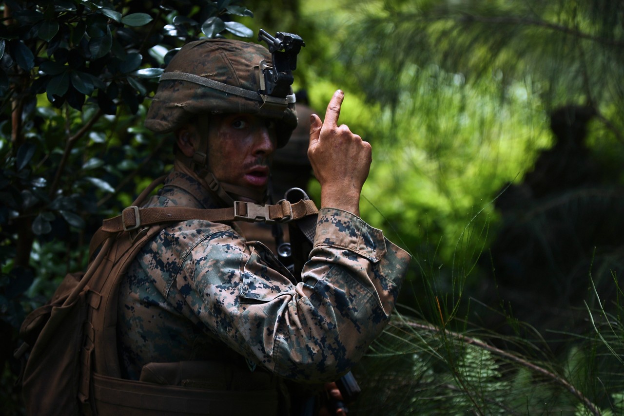 U.S. Marine Corps Sgt. Tyler Zeller, a rifleman with Echo Company, 2nd Battalion, 3rd Marine Regiment, signals his squad to provide 360 degree security during the Advanced Infantry Course (AIC) aboard Kahuku Training Area, Sept. 20, 2016. AIC is intermediate training designed to enhance and test the Marine's skills and leadership abilities as squad leaders in a rifle platoon. (U.S. Marine Corps Photo by Cpl. Aaron S. Patterson)