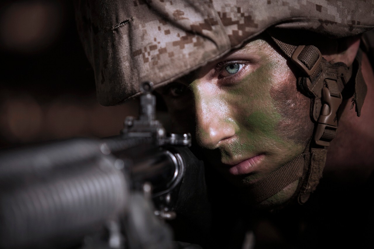 Marine looking through sight at target.