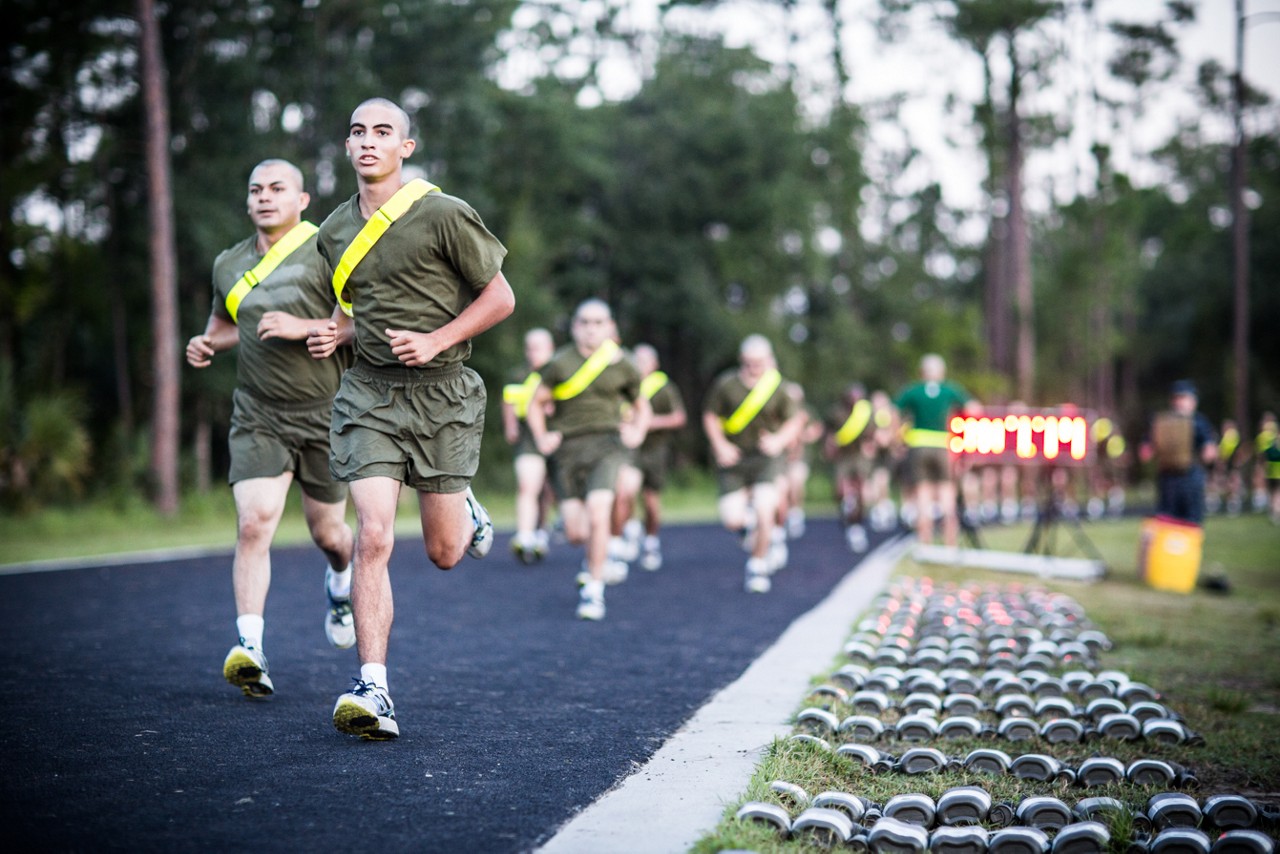 Aspiring Marines doing a timed run around a track.