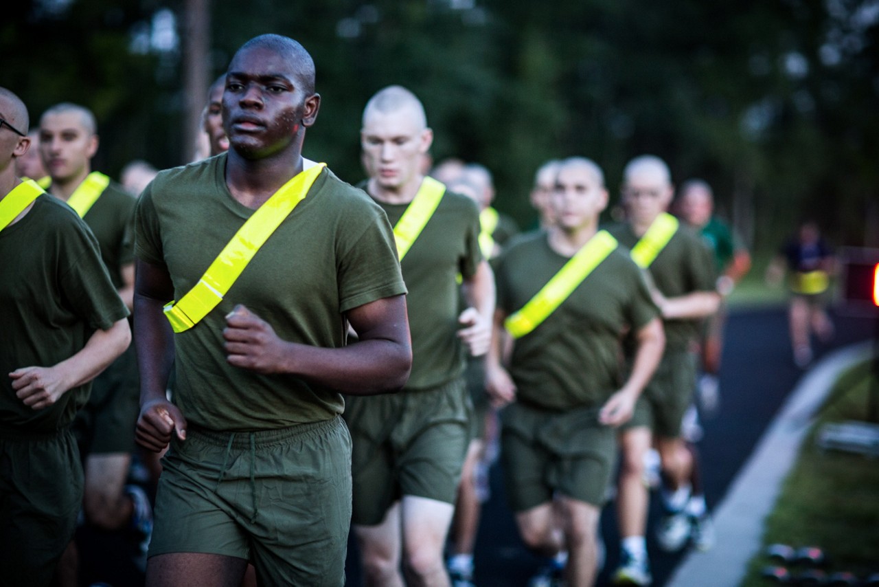 Aspiring Marine recruits doing pull ups as a group.