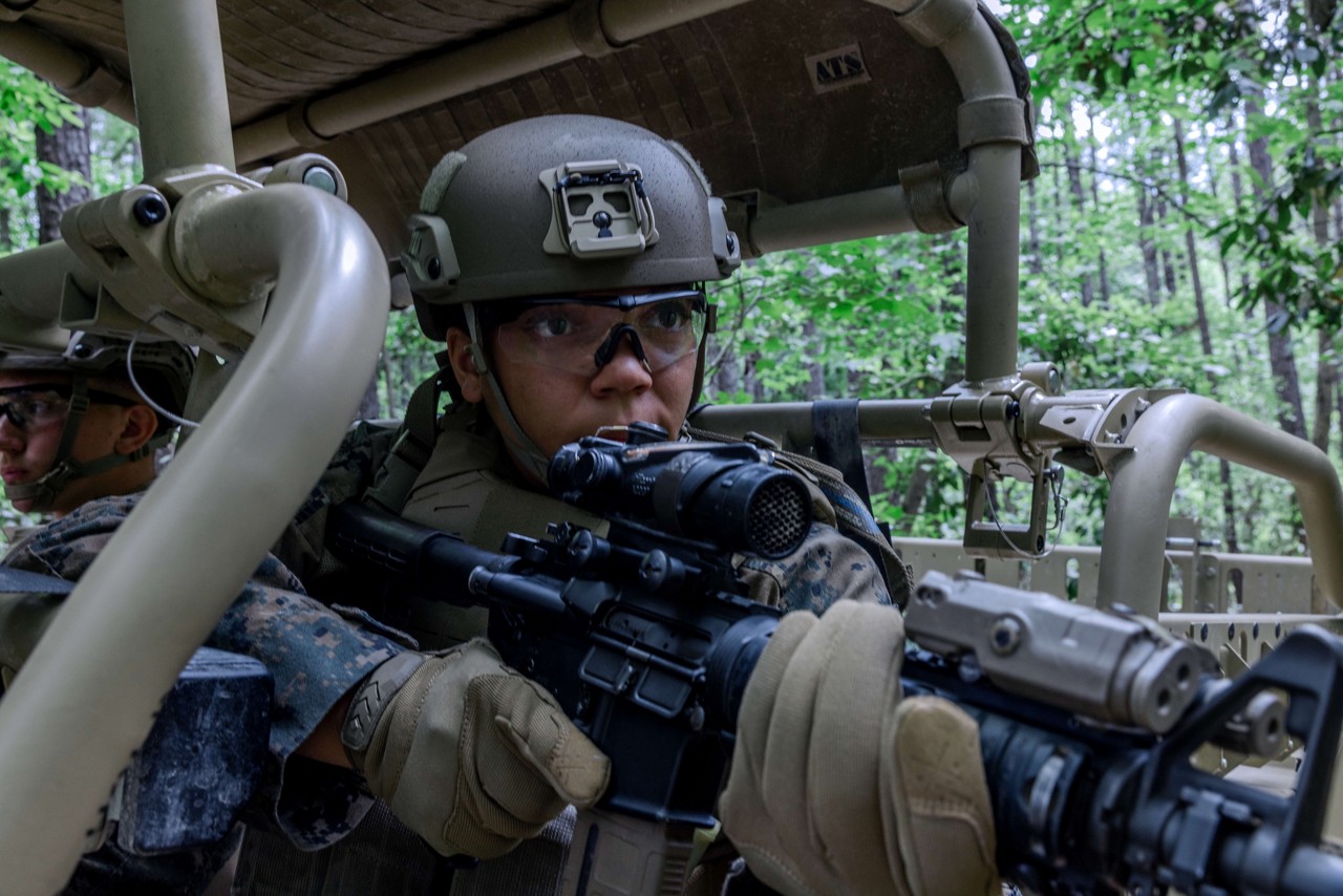 A U.S. Marine aims a rifle from a MRZR combat vehicle. 