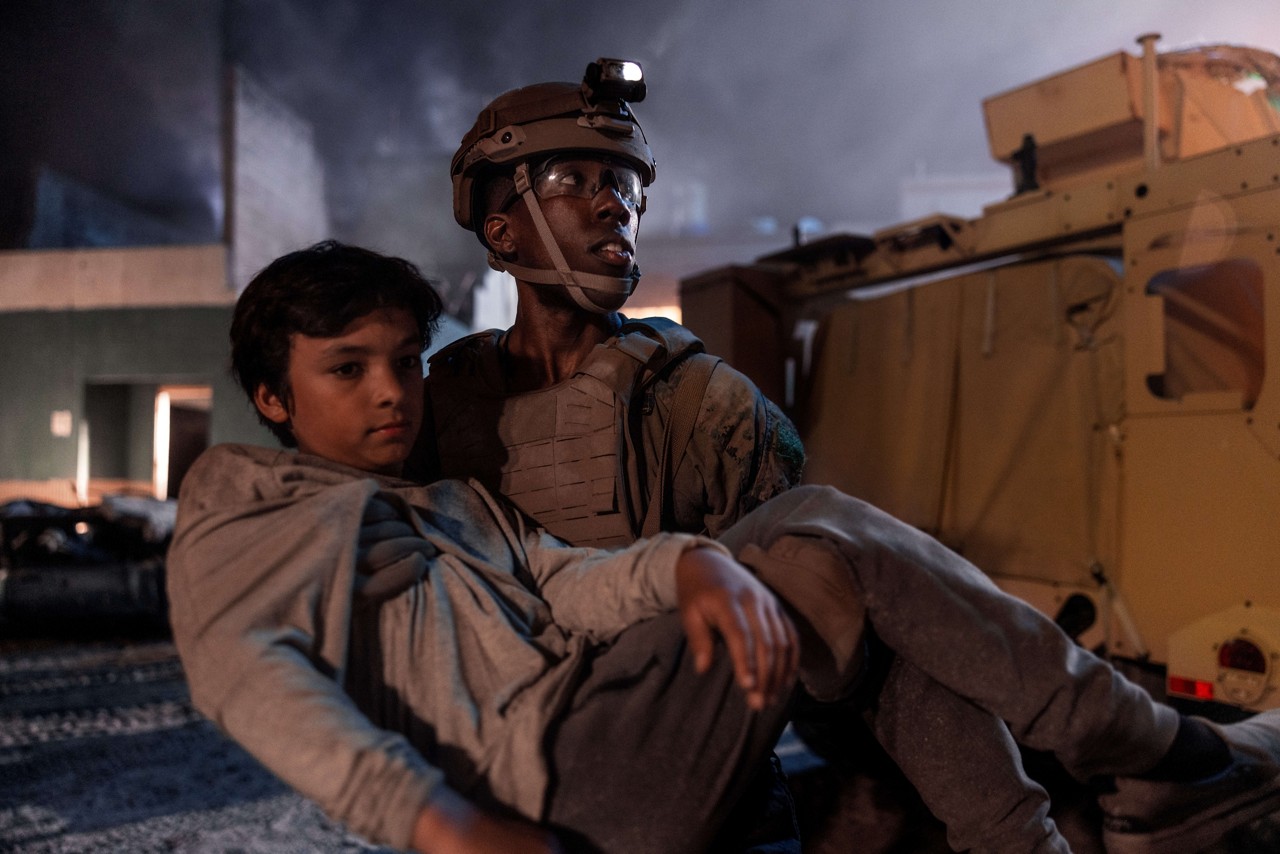 A U.S. Marine helps a young boy during a Humanitarian and Disaster Relief (HADR) mission. 