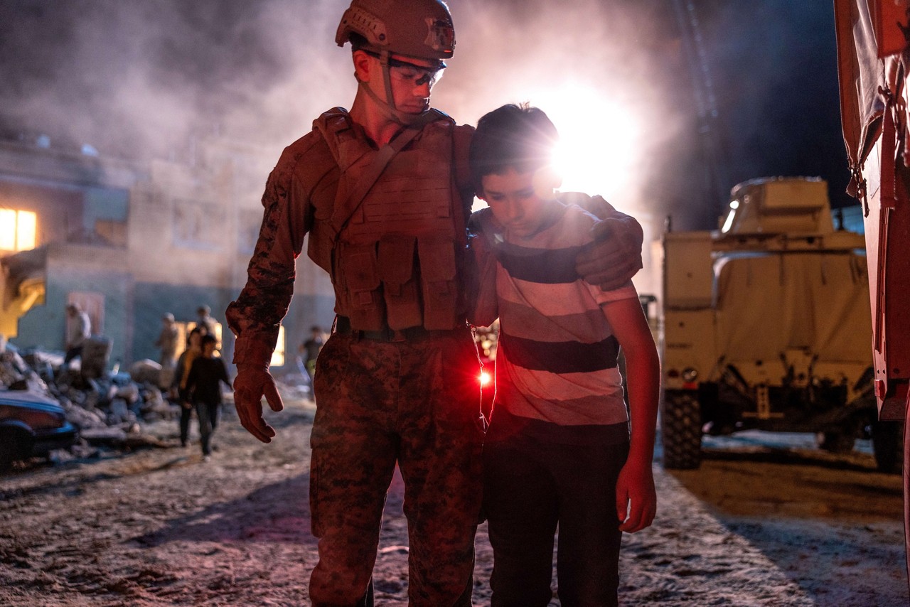 A U.S. Marine helps a young boy during a Humanitarian and Disaster Relief (HADR) mission. 