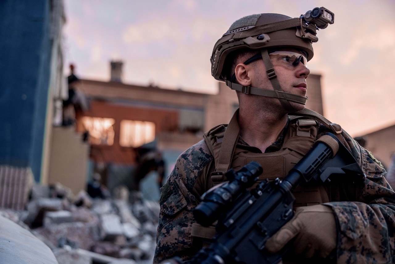 A U.S. Marine with a rifle looks across the battlefield. 